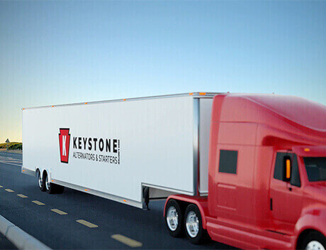 A red semi-truck with a trailer proudly displaying the Keystone logo and "Alternators & Starters" text cruises down the road, a striking example of branding reminiscent of Toronto Design Agency's finest works. Conte Studios