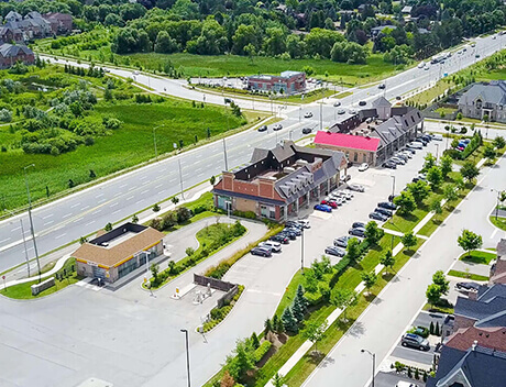 Aerial view of a suburban area with roads, parked cars, commercial buildings, and green spaces—home to thriving businesses like a leading Web Design Agency Toronto that transforms digital landscapes. Conte Studios