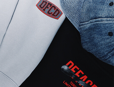 A close-up of Conte Studios clothing items showcases DFCD logos, including a grey cap, a white garment, and a black garment with striking red lettering. Conte Studios